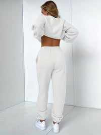 Frau in weißem Jogginganzug, Rückansicht, moderne Sportbekleidung, Freizeitmode, Indoor.