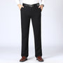 Mann in schwarzer Hose, weißem Hemd, braunen Schuhen, schwarzem Gürtel, Business-Look.
