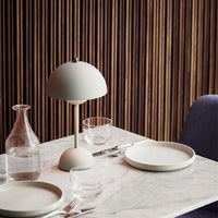 Moderne Tischlampe auf Marmortisch mit Geschirr, skandinavisches Design, minimalistisch.