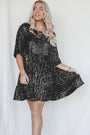 Frau in schwarzem Paillettenkleid, blondes Haar, modisches Outfit, festliche Kleidung.