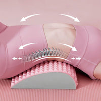 Frau auf rosa Yogamatte mit ergonomischem Rückenstützkissen zur Wirbelsäulenentlastung.