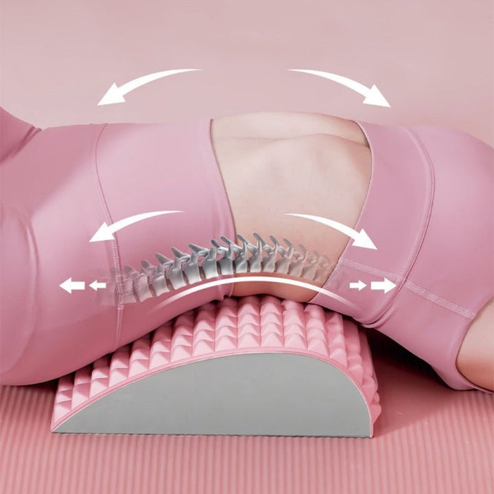 Frau auf rosa Yogamatte mit ergonomischem Rückenstützkissen zur Wirbelsäulenentlastung.
