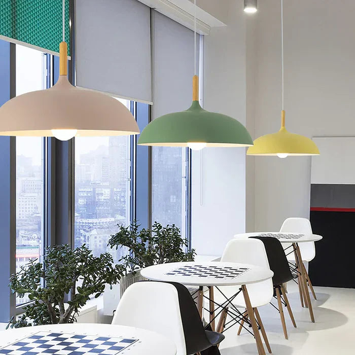 Moderne Hängelampen in Beige, Grün und Gelb über Esstischen in einem stilvollen Café.