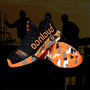 Schwarze und orangefarbene Sicherheitsschuhe mit Camouflage-Sohle, ideal für Bauarbeiten.