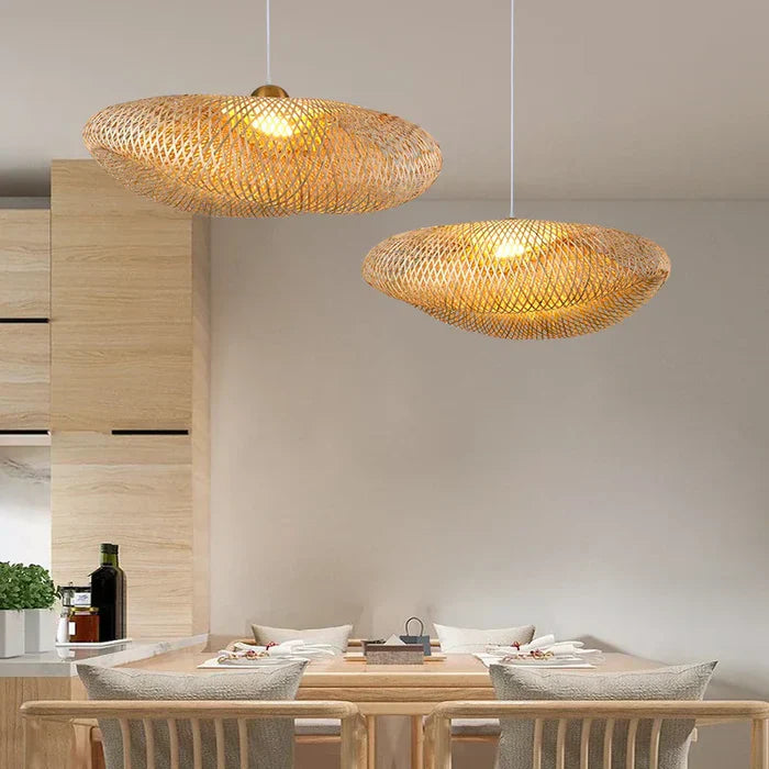 Zwei hängende Rattan-Pendelleuchten über Esstisch, modernes Design, warmes Licht.