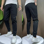 Schwarze Jogginghose Herren, Slim Fit, Baumwolle, sportlich, bequem, mit weißen Sneakers.