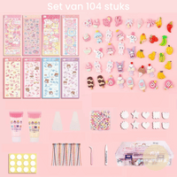 104-teiliges DIY-Nagelkunst-Set mit Aufklebern, Dekorationen und Werkzeugen, rosa Hintergrund.
