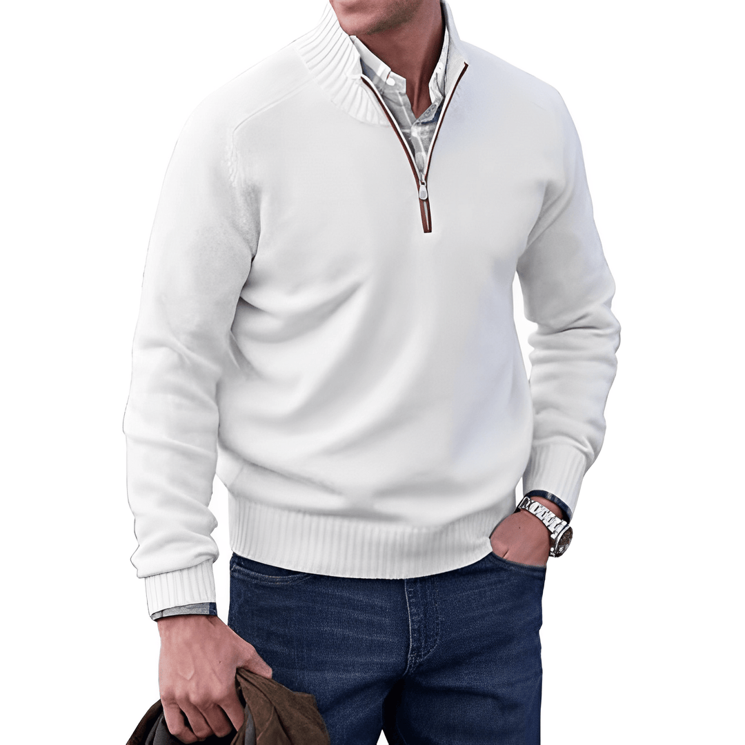 Mann in weißem Pullover mit Reißverschluss, blaue Jeans, hält braune Jacke, modisch, lässig.