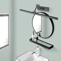 Runder schwarzer Wandspiegel mit Ablage und LED-Licht über modernem Waschbecken im Badezimmer.