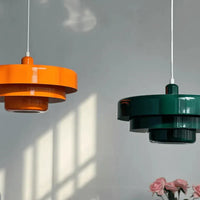 Zwei moderne Hängelampen, orange und grün, aus Metall, im skandinavischen Design.