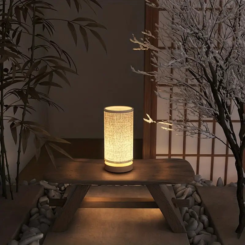 Japanische Tischlampe aus Holz und Stoff, warmes Licht, Zen-Dekor, minimalistisches Design.