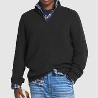 Schwarzer Herrenpullover mit Reißverschluss, gerippt, über kariertem Hemd, lässiger Stil.