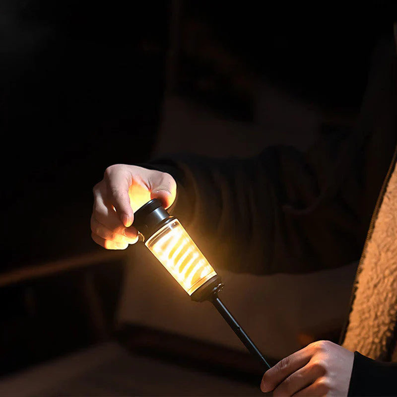 Person hält tragbare LED-Campinglampe, warmweißes Licht, Outdoor-Beleuchtung.
