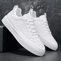 Weiße Sneaker aus Leder, perforiert, modisch, bequem, für Herren, auf grauem Hintergrund.