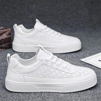 Weiße Sneaker aus Leder, perforiert, modisch, bequem, für Herren, auf grauem Hintergrund.