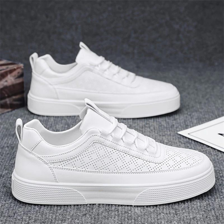 Weiße Sneaker aus Leder, perforiert, modisch, bequem, für Herren, auf grauem Hintergrund.