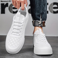Weiße Sneaker aus Leder, perforiert, modisch, unisex, lässig, mit Jeans kombiniert.