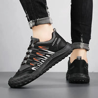 Schwarze Herren-Sneaker, atmungsaktiv, rutschfest, modisch, mit orangefarbenen Akzenten.
