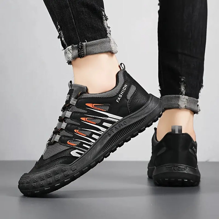 Schwarze Herren-Sneaker, atmungsaktiv, rutschfest, modisch, mit orangefarbenen Akzenten.