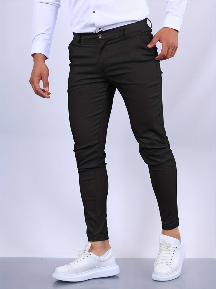 Mann in schwarzer Chinohose und weißen Sneakers, modische Herrenbekleidung.