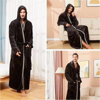 Mann im schwarzen Fleece-Bademantel mit Kapuze, dekorativem Saum, gemütlich im Wohnzimmer.
