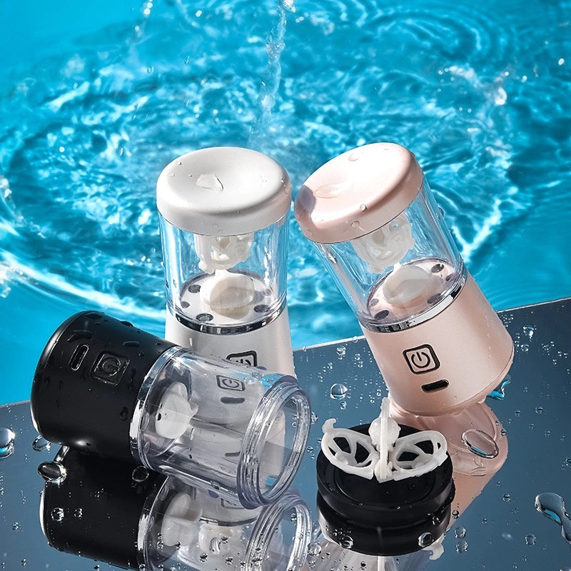 Drei tragbare Mini-Luftbefeuchter in Schwarz, Weiß und Rosa vor spritzendem Wasser.