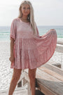Frau in rosa Paillettenkleid am Strand, Sommermode, elegantes Freizeitoutfit, Meereshintergrund.
