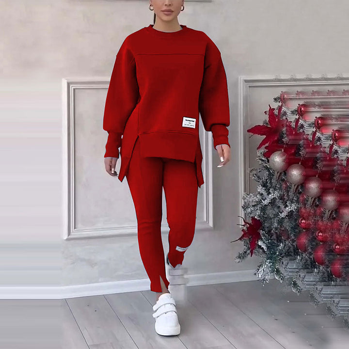 Frau in rotem Sweatshirt und Jogginghose, weiße Sneaker, Weihnachtsdeko im Hintergrund.