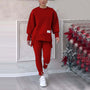 Frau in rotem Sweatshirt und Jogginghose, weiße Sneaker, Weihnachtsdeko im Hintergrund.