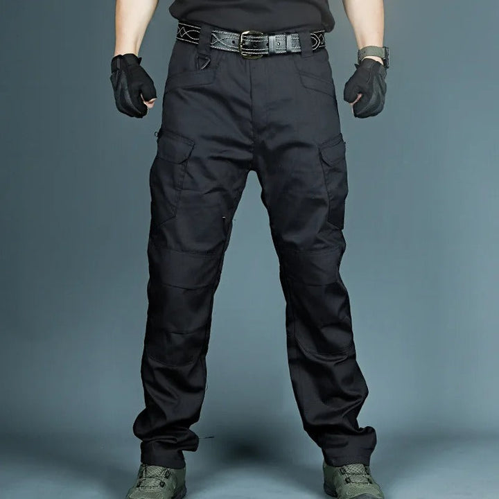 Schwarze taktische Hose, robust, mit Taschen, ideal für Outdoor-Aktivitäten und Arbeit.