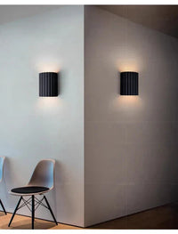 Schwarze Wandleuchte modern, zylindrisch, Innenbeleuchtung, minimalistisch, Wohnzimmer, Design.