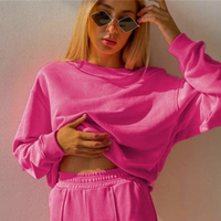 Frau in pinkem Sweatshirt und Jogginghose, modisch, lässig, Sonnenbrille, Freizeitkleidung.