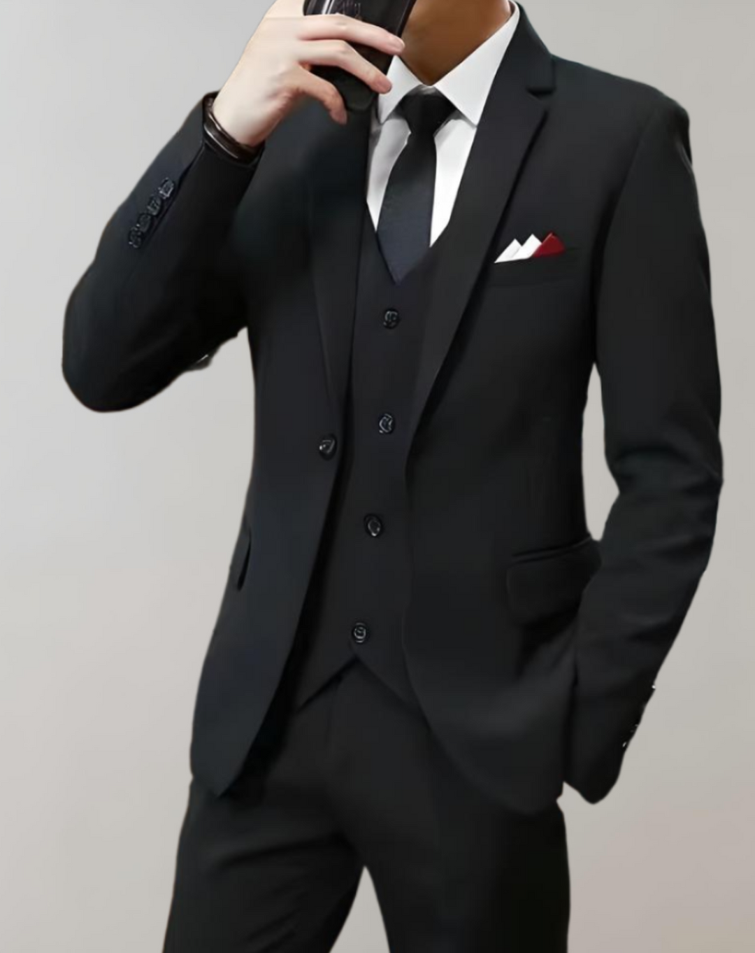 Mann im eleganten schwarzen Anzug mit Krawatte und Einstecktuch, Businessmode Herren.