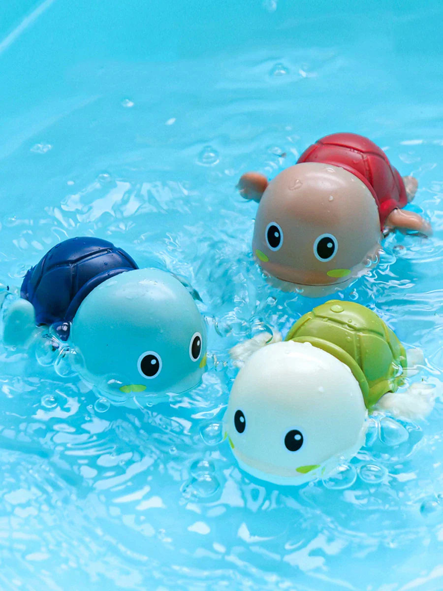 Bunte schwimmende Schildkröten-Badespielzeuge im Wasser, Kunststoff, Kinder, blau, rot, grün.