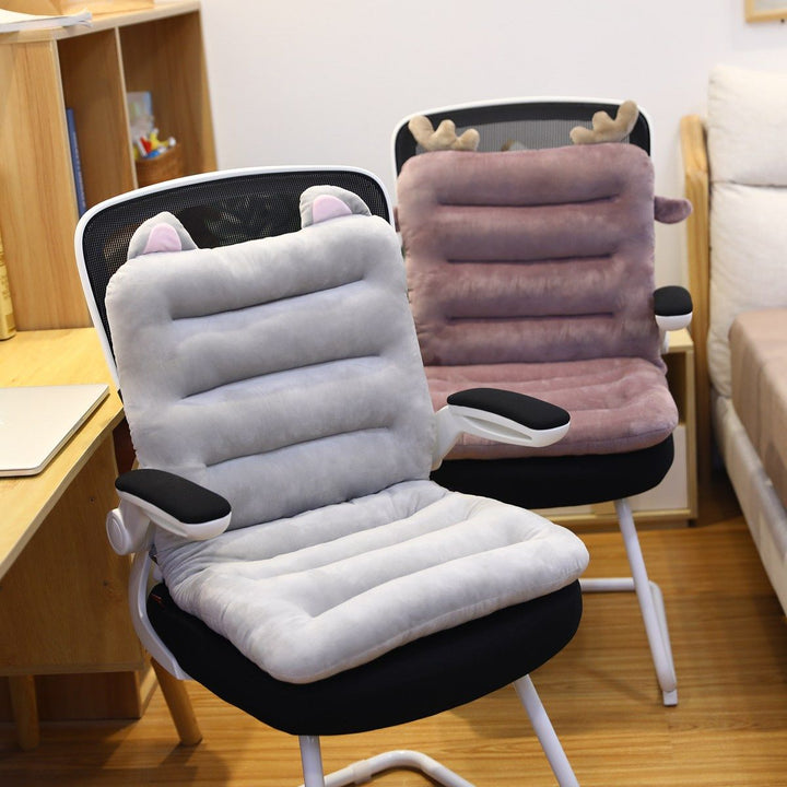Graue und rosa Plüsch-Sitzkissen mit Tierohren auf Bürostühlen im modernen Arbeitszimmer.
