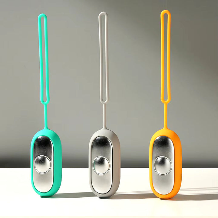 Drei tragbare Mini-Luftbefeuchter in Türkis, Grau und Orange mit Silikonband auf weißem Tisch.