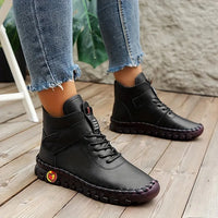 Schwarze Lederstiefel für Damen, lässig, mit Schnürung, auf Holzboden, modisch, bequem.