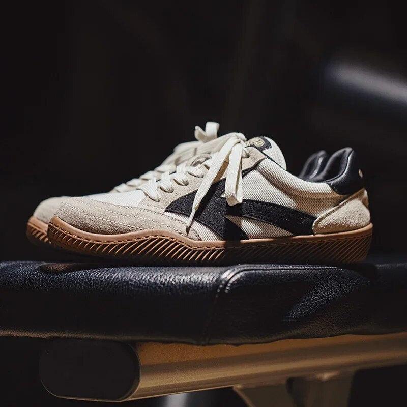 Weiße Sneaker mit schwarzem Streifen, Gummisohle, auf schwarzer Bank, modisch, sportlich.