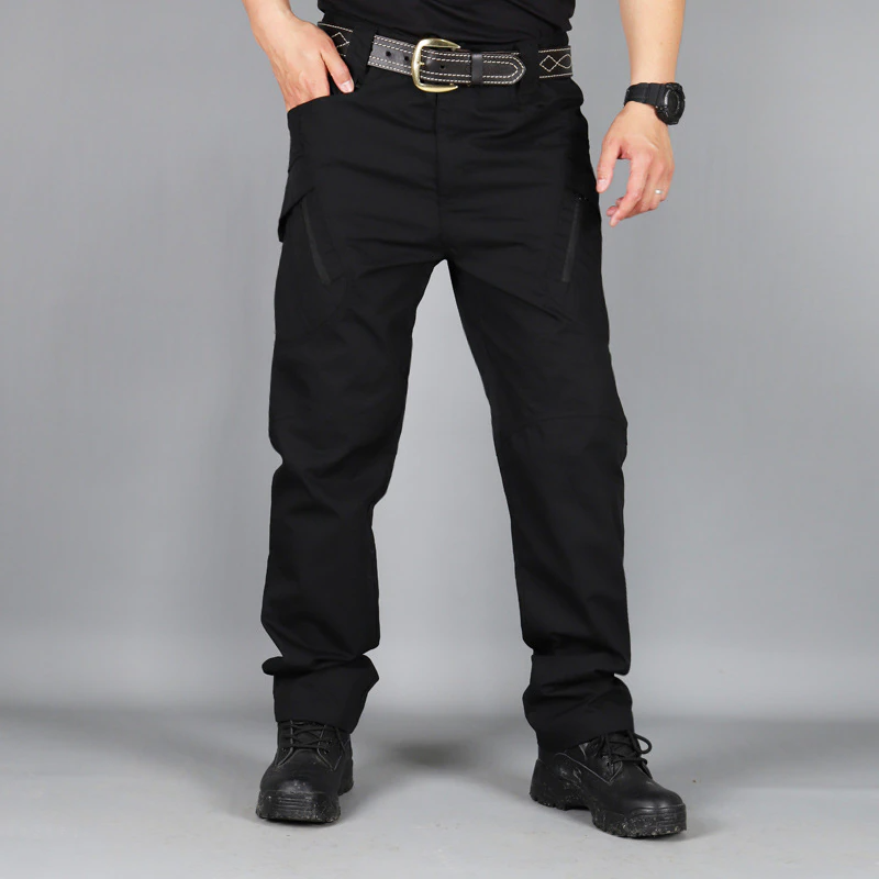Mann in schwarzer taktischer Hose, schwarzem Gürtel und Stiefeln, ideal für Outdoor-Aktivitäten.