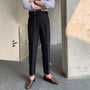 Mann in schwarzer Anzughose, braune Loafer, gestreiftes Hemd, moderne Herrenmode.