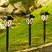 Drei schwarze Solar-Gartenleuchten auf Rasen, LED, wetterfest, energiesparend.