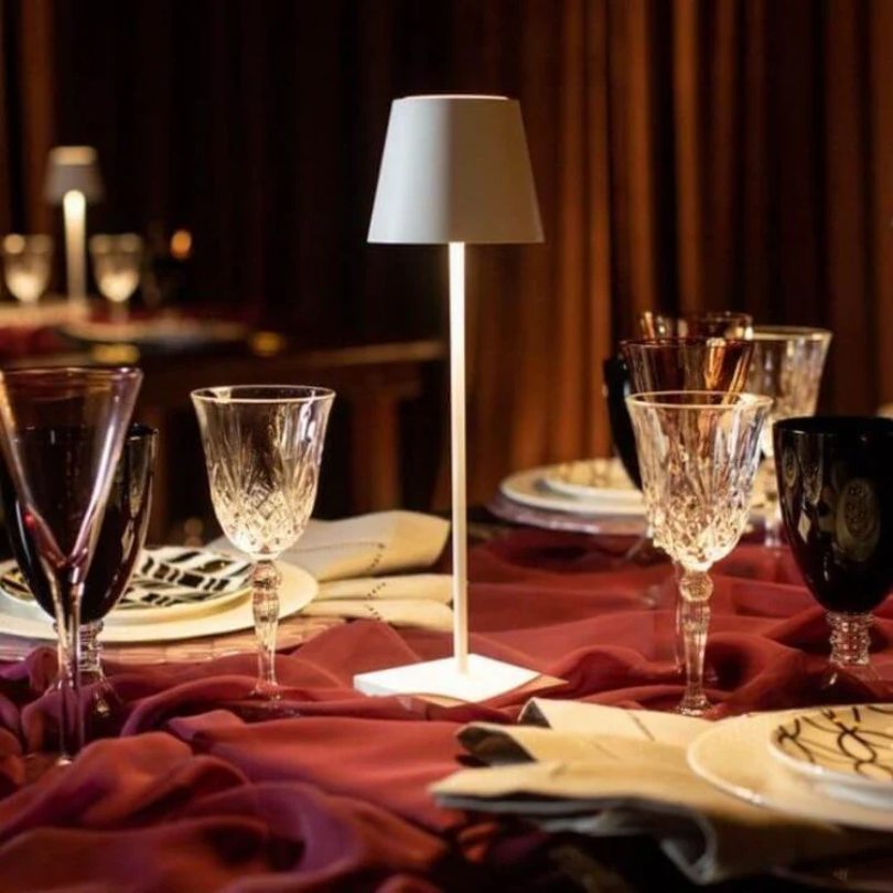 Elegante Tischlampe auf gedecktem Tisch mit Kristallgläsern und violettem Tischtuch.
