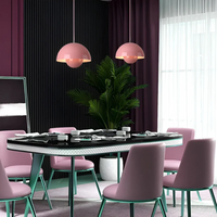 Runder Esstisch mit rosa Stühlen, modernen Pendelleuchten, Pflanzen, lila Vorhängen im Esszimmer.