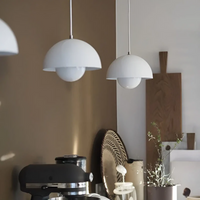 Zwei weiße Pendelleuchten in moderner Küche, skandinavisches Design, Holz- und Metallakzente.