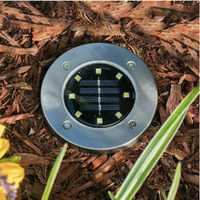 Runde Solar-Bodenleuchte aus Edelstahl im Garten, energieeffiziente Außenbeleuchtung.
