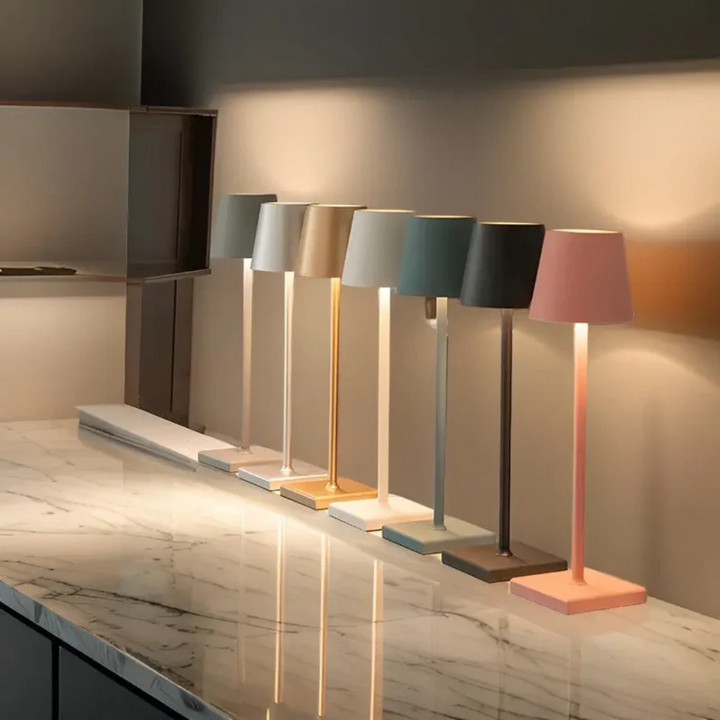 Sechs moderne Tischlampen in verschiedenen Farben auf Marmortisch, LED, minimalistisches Design.