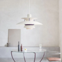 Moderne weiße Pendelleuchte über rundem Glastisch in minimalistischem Wohnzimmer.