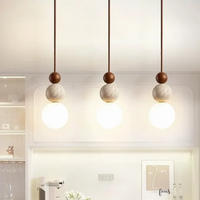 Drei moderne Pendelleuchten aus Holz und Beton, minimalistisch, warmweißes Licht, Wohnzimmer.