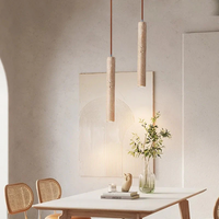 Zwei hängende Pendelleuchten aus Holz über einem Esstisch in modernem, minimalistischem Design.