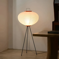 Stehlampe mit Papierlampenschirm, schwarzem Metallgestell, warmes Licht, modernes Design.